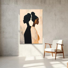 Load image into Gallery viewer, Abstract painting of two women's profiles on a wall with a brown wooden chair below.